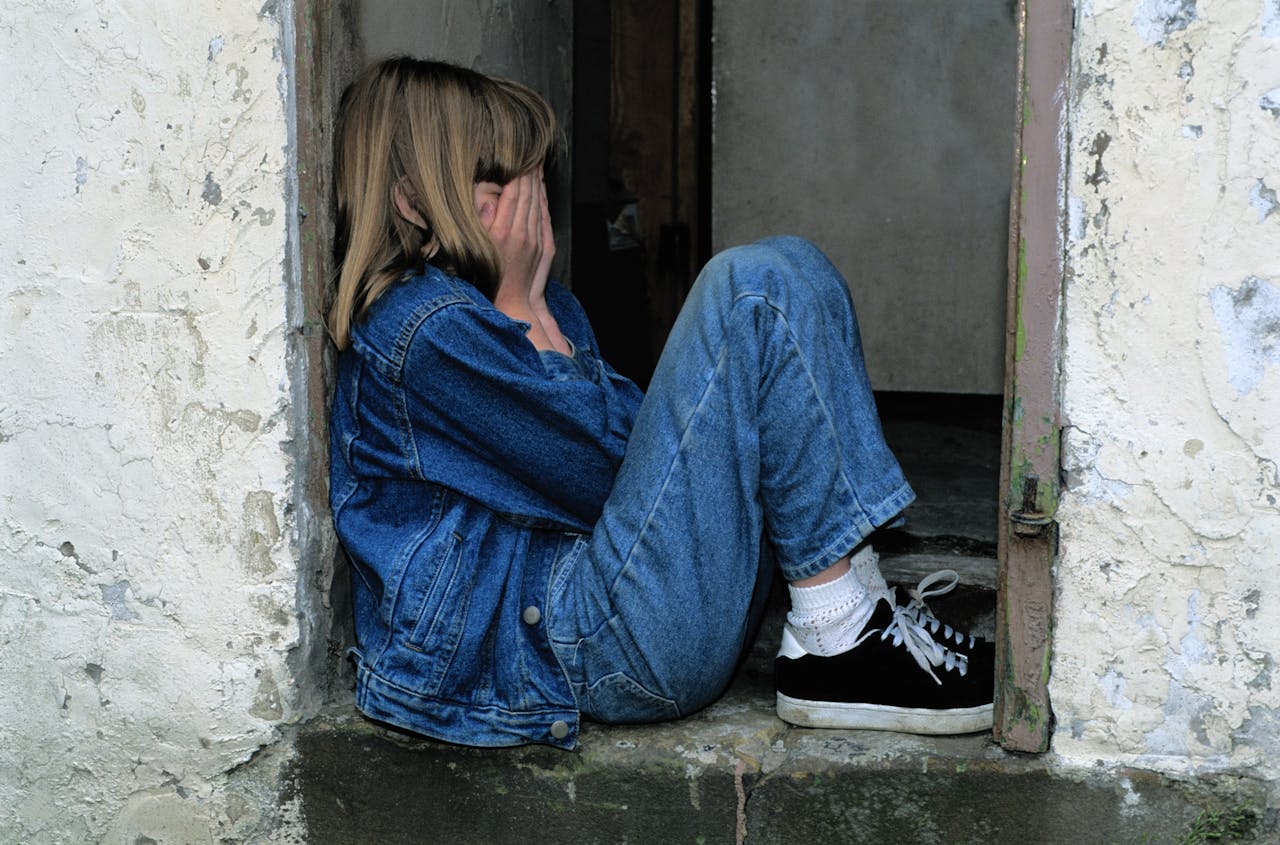 sad girl leaning against a wall