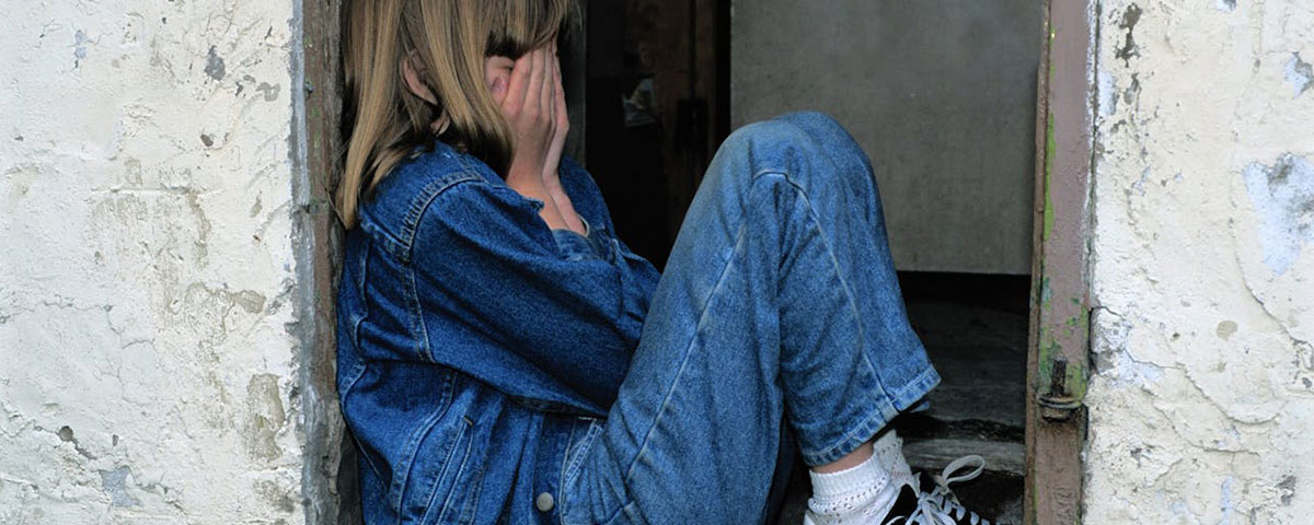 sad girl leaning against a wall