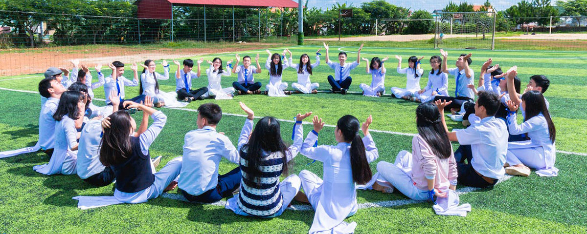 students sitting in a circle in a school playground