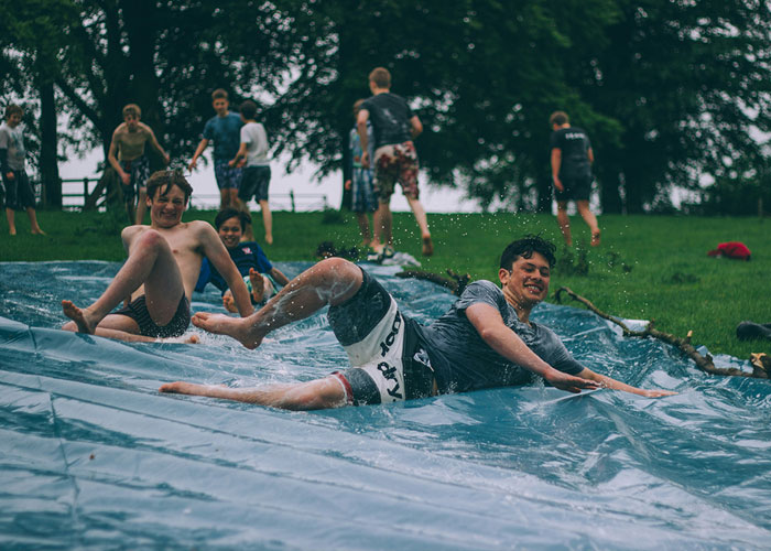 a group of boys playing on a water slide