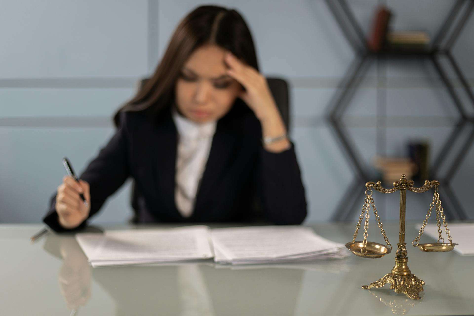 an exhausted lawyer reading some documents on her desk