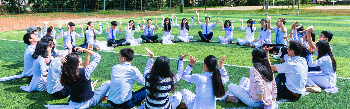 students sitting in a circle in a school playground