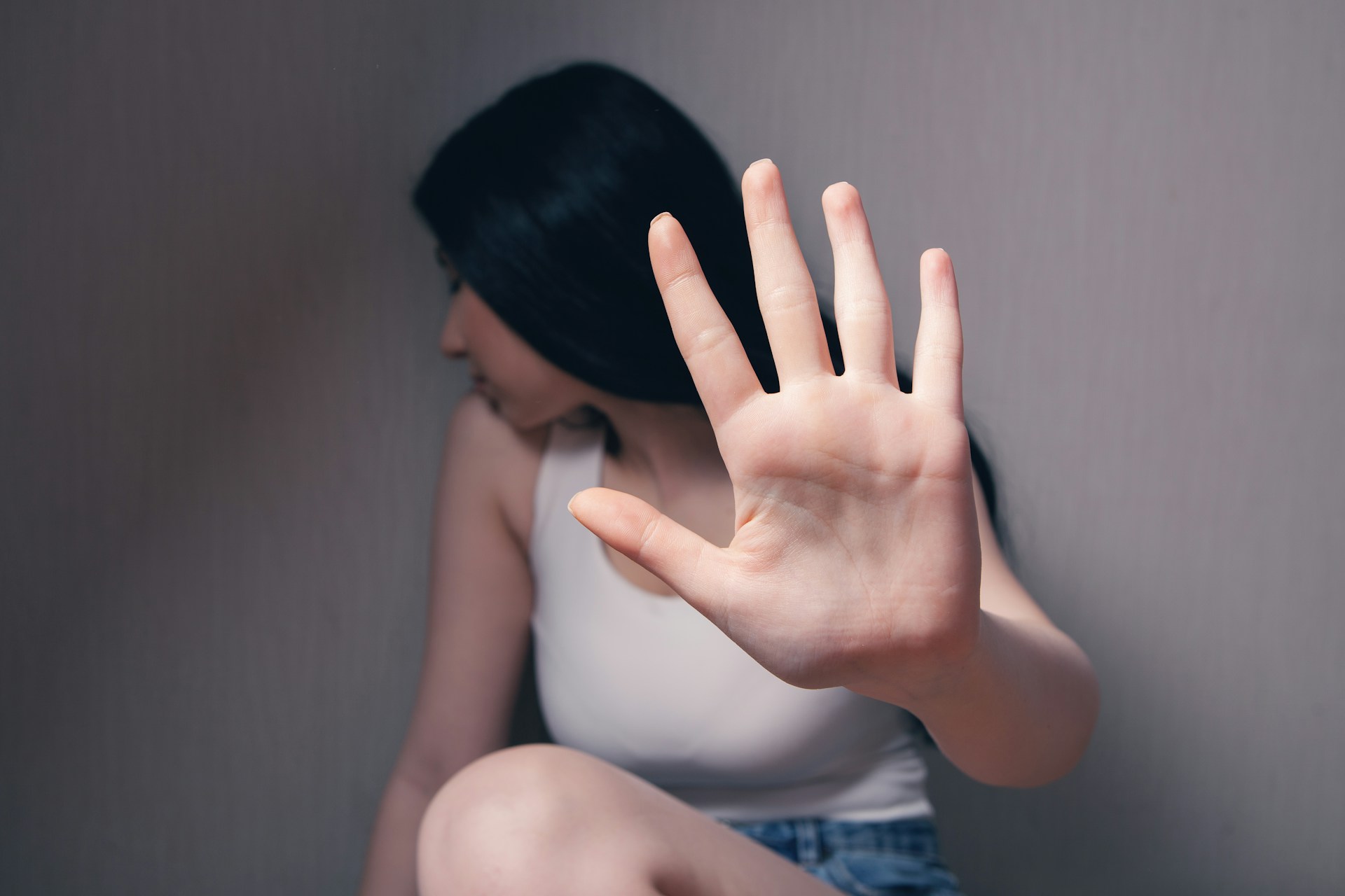 A young woman holding out her hand to resist sexual harassment