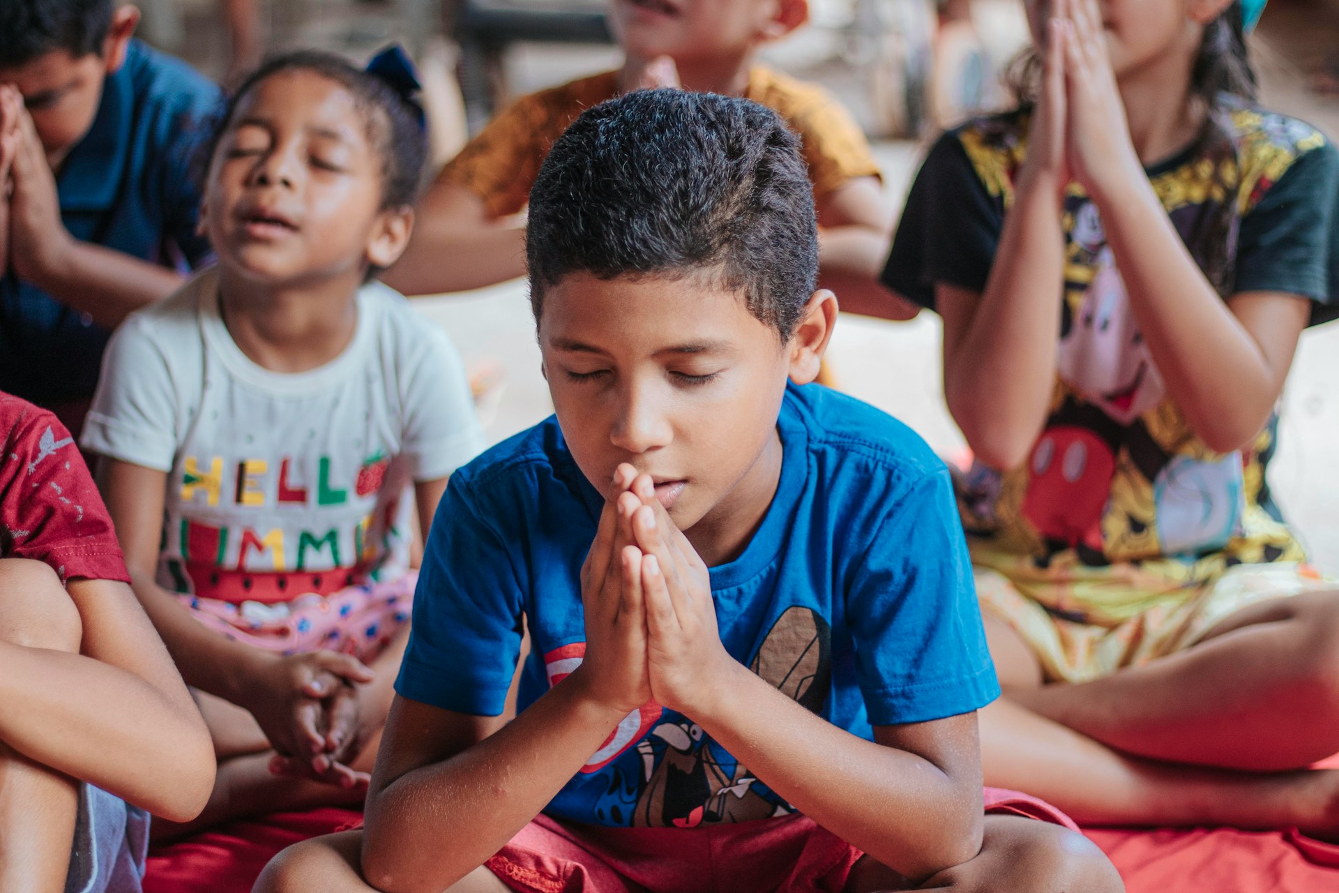 Children seated on the floor praying