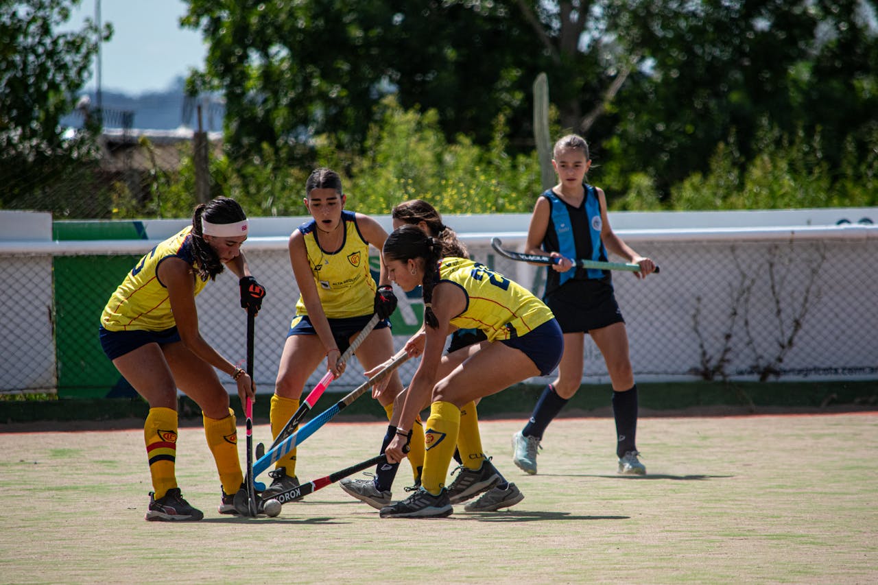 Women playing field hockey