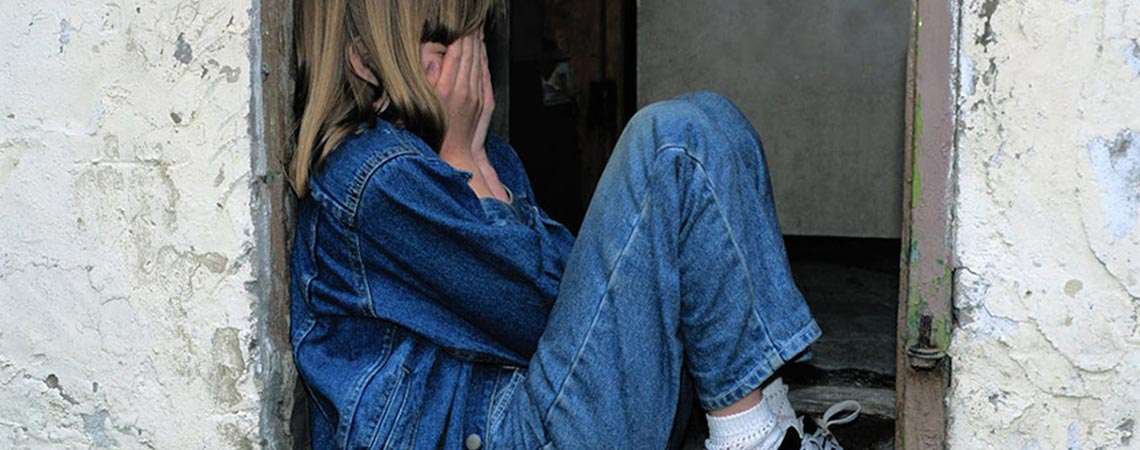 A student covering her face with her hands