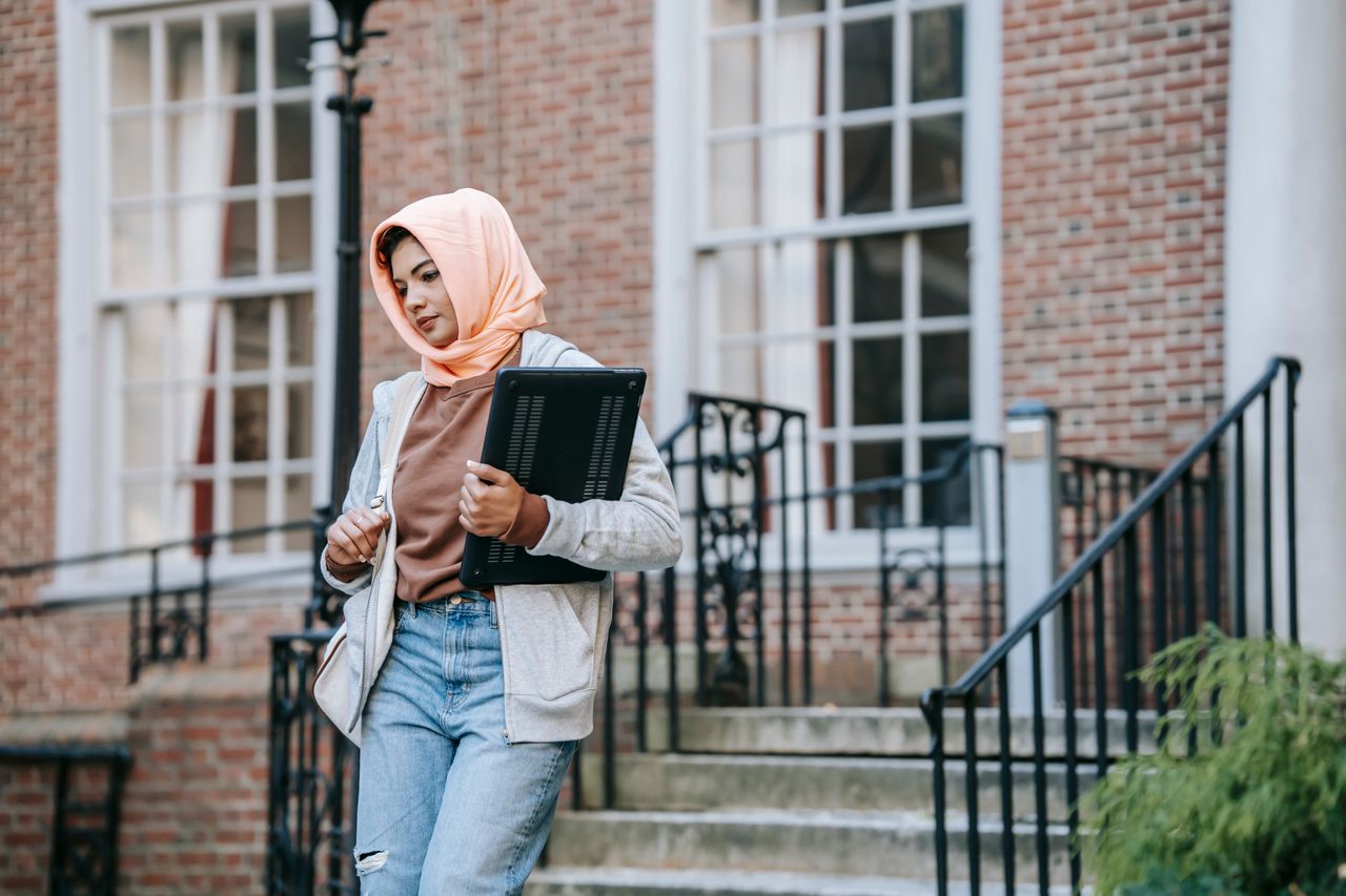 A Muslim student walking down a set of stairs