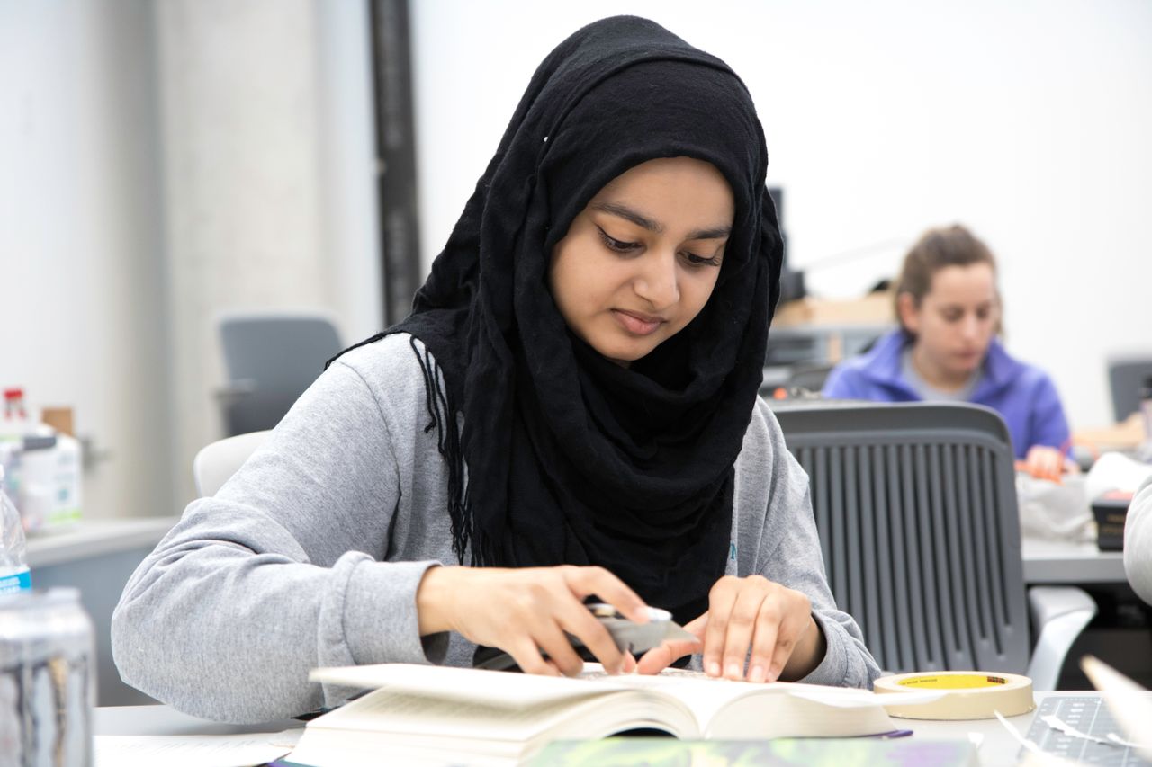 A student in class wearing a black hijab