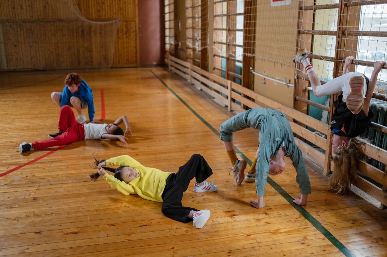 Students engaging in acrobatic exercises in a school gym
